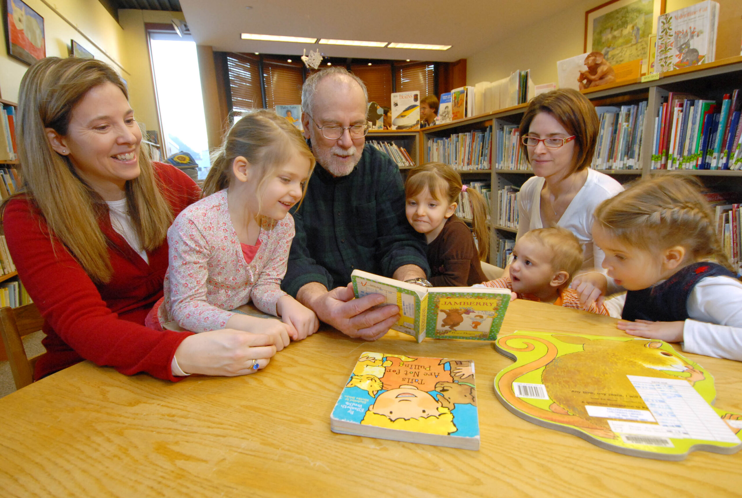 Multigenerational family reads a book together in the Children's Library