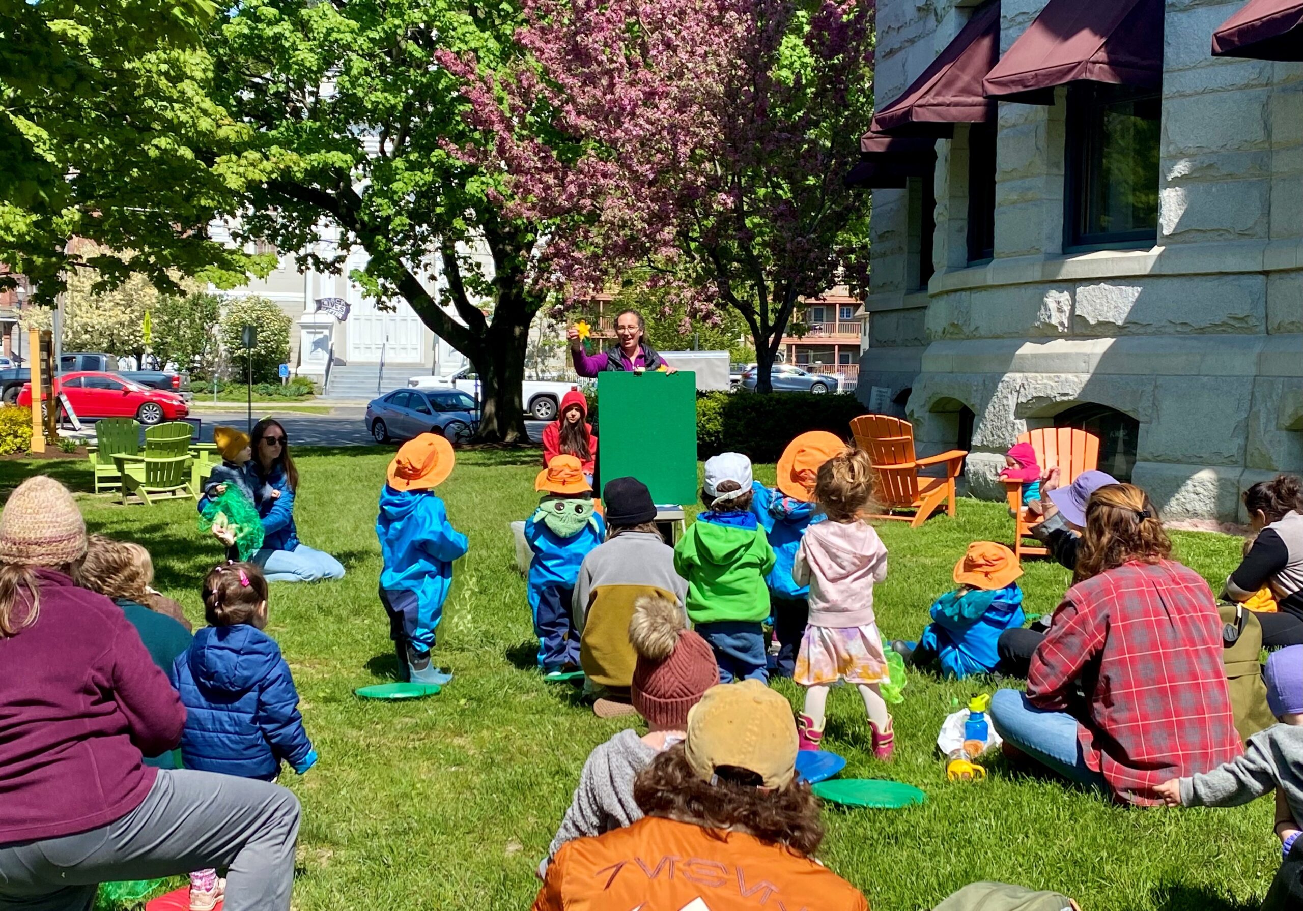 Librarian leading an outdoor storytime for children