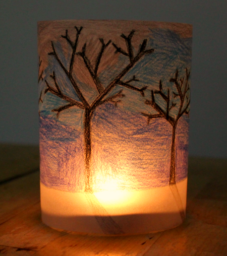 Image of a glowing handmade paper lantern with trees drawn on it.