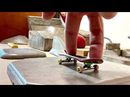 Image of two fingers on a finger board skateboard.