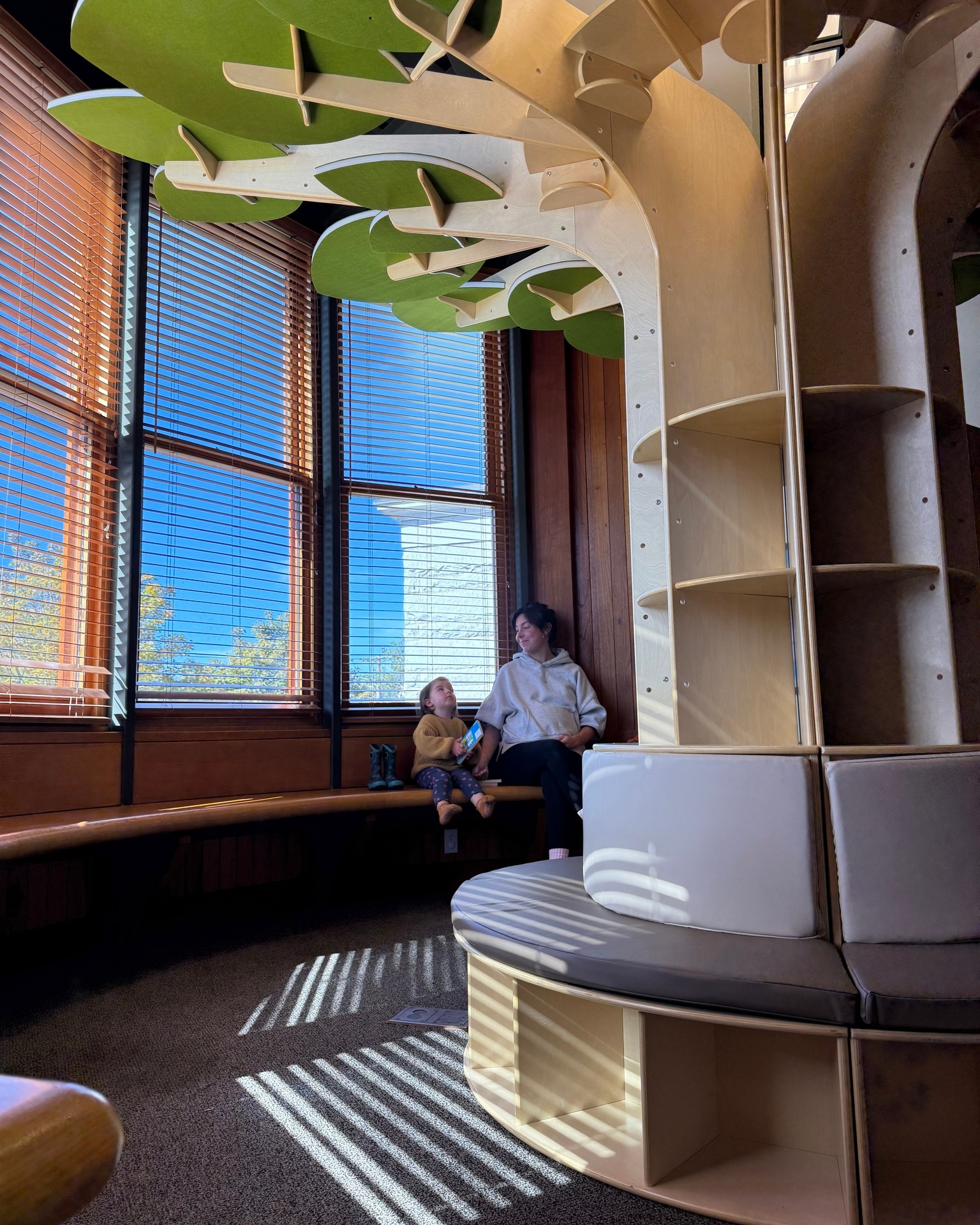 Pictured: Elaine and Maeve enjoy the latest addition to the Children's Library, our brand-new reading tree.