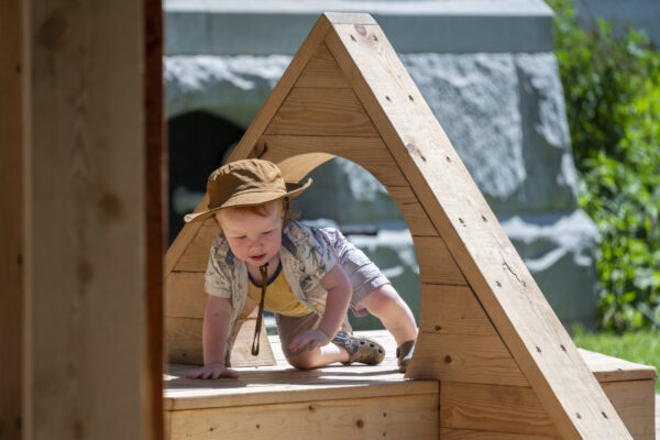 A small child crawls on playscape